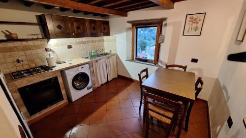 eine Küche mit einem Tisch, einem Herd und einer Waschmaschine in der Unterkunft Appartamento con vista su Firenze in Lastra a Signa