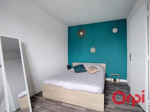 um quarto com uma cama com uma parede azul em Bel appartement 2/4 pers 1ch em Antony