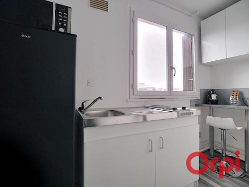 a kitchen with a black refrigerator and a sink at Bel appartement 2/4 pers 1ch in Antony