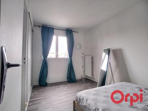 a bedroom with a bed and a window with blue curtains at Bel appartement 2/4 pers 1ch in Antony