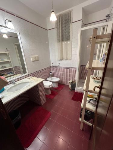 bagno con lavandino, servizi igienici e specchio di A Casa del Ferdy a Caserta