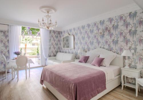 um quarto com uma cama, uma mesa e uma cadeira em Cannes Imperial Croisette Palais Miramar em Cannes