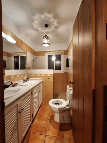 a bathroom with a toilet and two sinks at Villa Itaca in Mijas