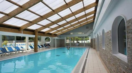 a large swimming pool with a skylight in a building at Détente et confort au Bois Dormant camping 4* MH240 in Saint-Jean-de-Monts