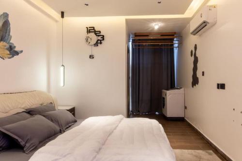 a bedroom with a large white bed and a window at Petunia Apartment in Accra