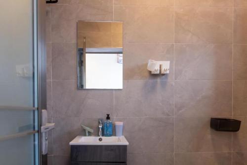 bagno con lavandino e specchio di Petunia Apartment a Accra