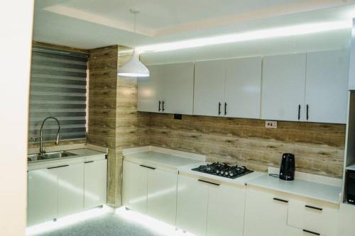 eine weiße Küche mit weißen Schränken und einem Waschbecken in der Unterkunft 3 bedroom service apartment Victoria Island Aij Residence in Lagos