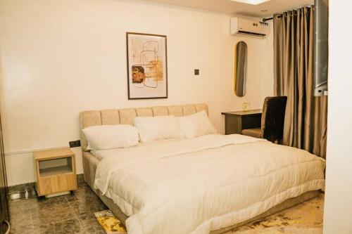 a bedroom with a large bed and a desk at 3 bedroom service apartment Victoria Island Aij Residence in Lagos