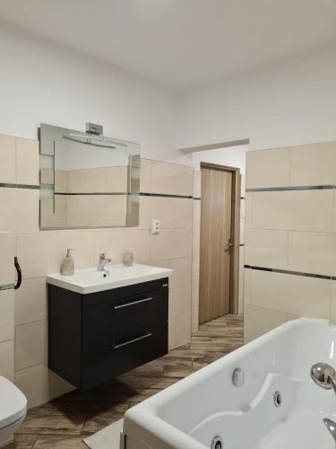 a white bathroom with a tub and a sink at Casa Nico in Coşna