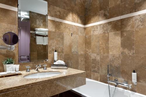 a bathroom with a sink and a shower at Hôtel du Château & Spa - Teritoria in Carcassonne