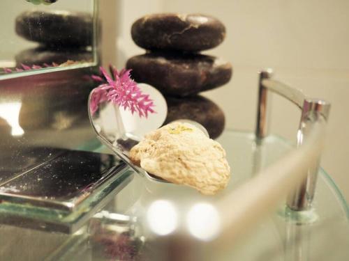 a glass table with a bowl of rocks and a flower at LOVE and Relax at Dream Catcher Retreat in Whitby