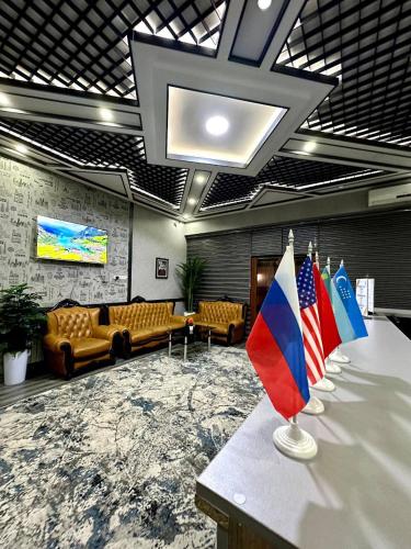 a lobby with couches and flags on a table at Amor Fati INN Hotel in Tashkent