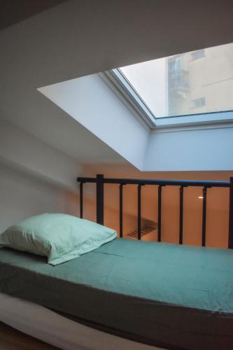 un lit dans une chambre avec une grande fenêtre dans l'établissement STA5 Cannes, le suquet, à Cannes