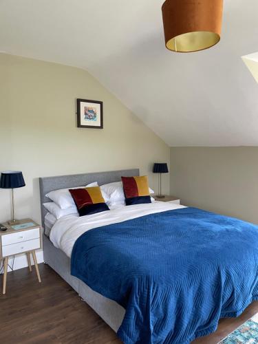 a bedroom with a large bed with a blue blanket at Doolin Village Accomodation in Doolin