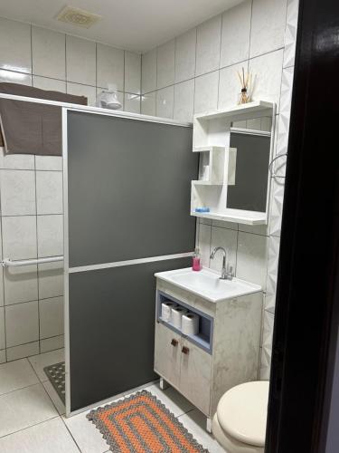 uma casa de banho com um lavatório, um WC e um espelho. em Casa das Suculentas em Jaraguá do Sul