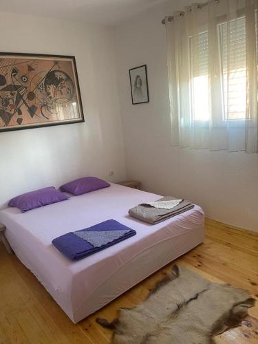 a bedroom with a large bed with purple pillows at Njegusi-Cetinje in Njeguši