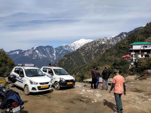 a group of people standing next to cars on a mountain at Amazing view Home Stay in McLeod Ganj