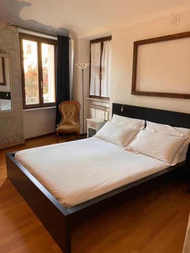 1 cama grande en un dormitorio con silla en Villa Dina, en Candelo