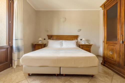a bedroom with a large bed and two night stands at Hotel Sa Suergia in Villasimius