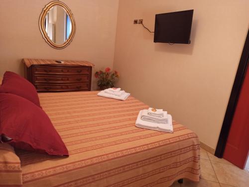 ボナッソーラにあるAppartamento Via Rezzano vista mareのベッドとテレビが備わるホテルルームです。