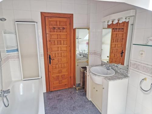 a bathroom with a sink and a toilet and a door at Villa Rural Cantabria in Pechón