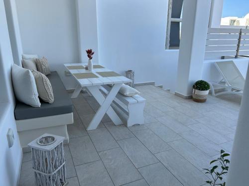 a white patio with a bench and a table at Thiramor houses in Mesaria