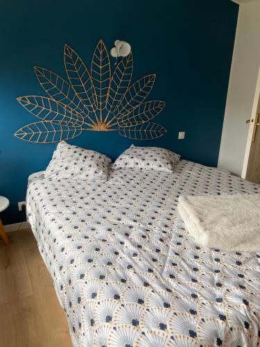 1 dormitorio con 1 cama con pared azul en chambre double blue lagoon Spa Piscine, en Idron