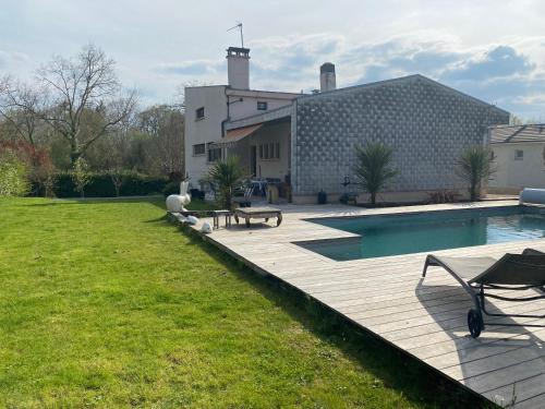 une cour arrière avec une piscine et un bâtiment dans l'établissement 2 chambres dans villa avec spa et piscine, à Idron