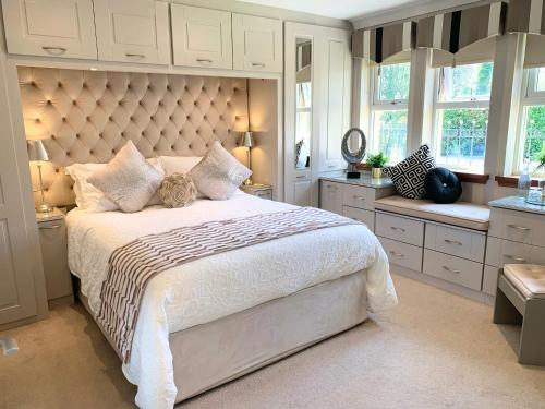 a bedroom with a large bed with a large headboard at Ayrs and Graces - Luxury Bed and Breakfast in Ayr