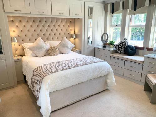 a bedroom with a large bed with a large headboard at Ayrs and Graces - Luxury Bed and Breakfast in Ayr