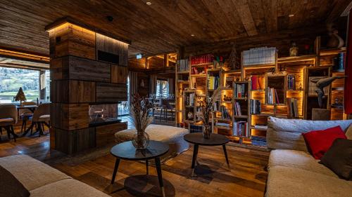 a living room with a couch and bookshelves at LA CABANE DU BREUIL in La Bresse