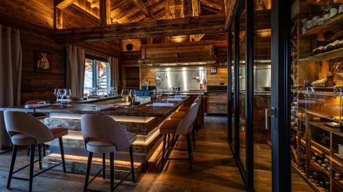 a kitchen with a large bar with stools at LA CABANE DU BREUIL in La Bresse