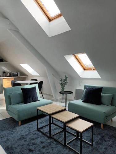 una sala de estar con 2 sofás azules y una mesa. en T2 Cozy Rungis, en Rungis