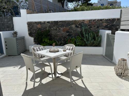 a white table and chairs on a patio at Thiramor houses in Mesaria