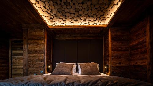 a bedroom with a large bed with a light above it at LA CABANE DU BREUIL in La Bresse