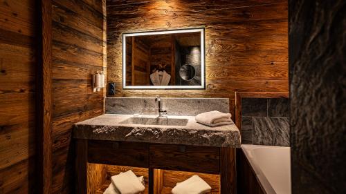 a bathroom with a sink and a mirror at LA CABANE DU BREUIL in La Bresse