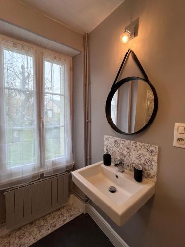 une salle de bain avec un lavabo et un miroir dans l'établissement Le Cantou, à Affieux