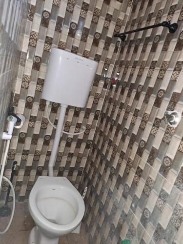 a bathroom with a toilet and a shower curtain at Roof Top Private House in Lamu