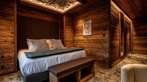 a bedroom with a bed in a log cabin at LA CABANE DU BREUIL in La Bresse
