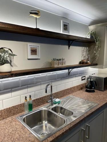 a kitchen counter with a stainless steel sink at Seaside Modern Apartment in Westward Ho
