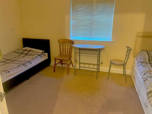 1 Schlafzimmer mit einem Bett, einem Tisch und 2 Stühlen in der Unterkunft Private Room In Birmingham in Birmingham