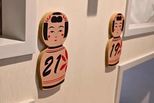 two wooden figurines of a person on a wall at Hotel Tomariya Ueno in Tokyo