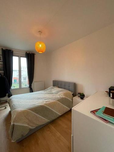 - une chambre avec un lit dans une chambre avec un bureau dans l'établissement Joli 2 pièces à Pantin au porte de Paris, à Pantin