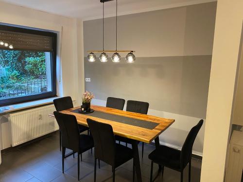 - une salle à manger avec une table et des chaises en bois dans l'établissement Ferienvilla Whirlpool Fasssauna direkt am Rhein, à Götterswickerhamm