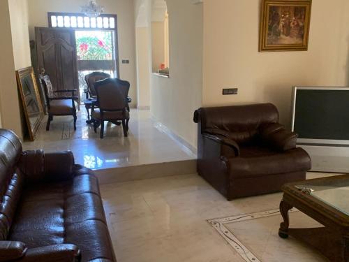 a living room with leather furniture and a flat screen tv at Villa Sarah in Ifoutatsene