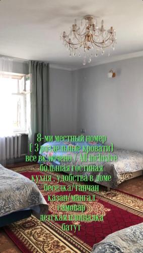 1 dormitorio con 2 camas y lámpara de araña en Bura Eco House, en Burabay