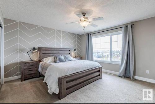 een slaapkamer met een bed en een plafondventilator bij Best home with lake view in Edmonton