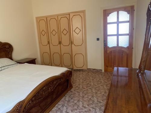 a bedroom with a bed and a wooden door at Villa Sarah in Ifoutatsene