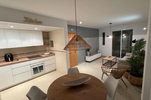 uma cozinha e uma sala de estar com mesa e cadeiras em Apto a 1 min de la playa em Carboneras