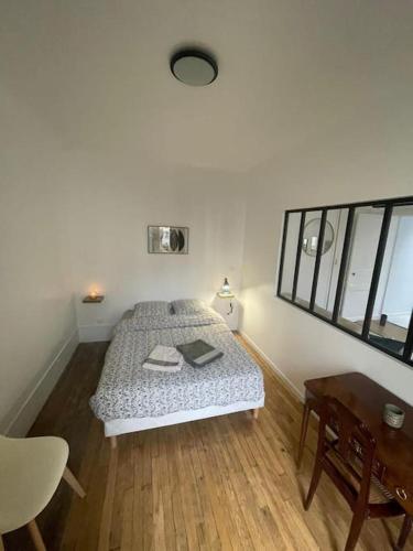 une petite chambre avec un lit et une table dans l'établissement Cosy au centre de Paris, à Paris